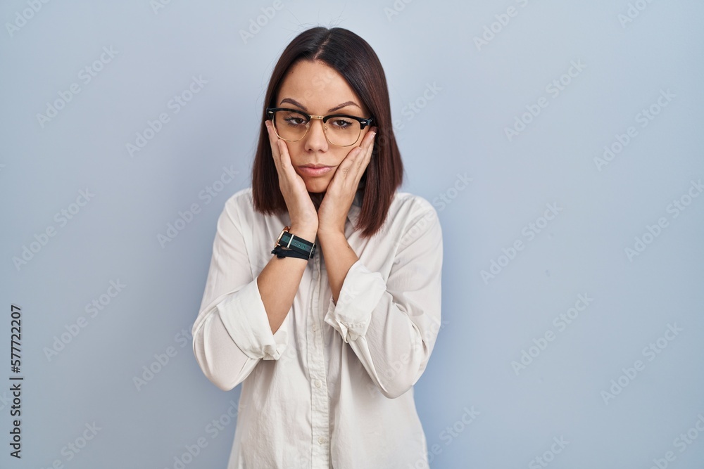 Young hispanic woman standing over white background tired hands covering face, depression and sadness, upset and irritated for problem Young hispanic woman standing over white background tired hands covering face, depression and sadness, upset and irritated for problem