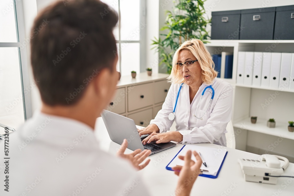 Middle age man and woman doctor and patient having medical consultation at clinic Middle age man and woman doctor and patient having medical consultation at clinic