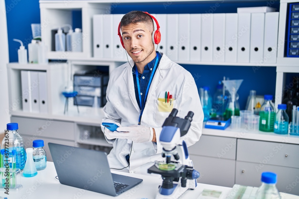 Young hispanic man scientist using laptop and smartphone at laboratory Young hispanic man scientist using laptop and smartphone at laboratory
