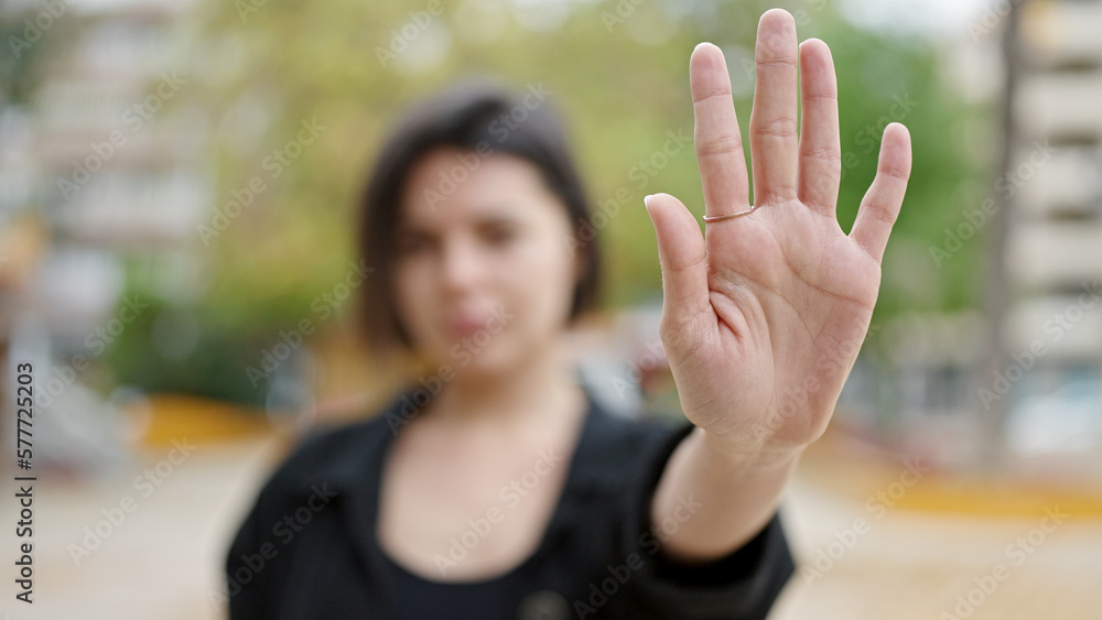 Young caucasian woman doing stop gesture with hand at park Young caucasian woman doing stop gesture with hand at park