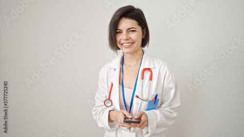 Young caucasian woman doctor smiling confident using smartphone over isolated white background