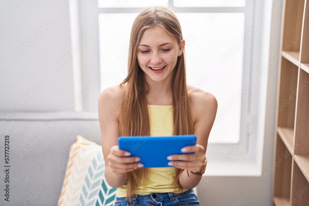 Young caucasian woman using touchpad sitting on sofa at home Young caucasian woman using touchpad sitting on sofa at home