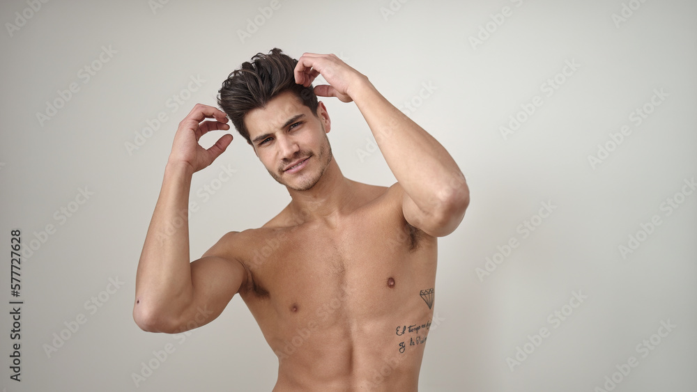 Fototapeta premium Young hispanic man smiling confident combing hair with hands over isolated white background