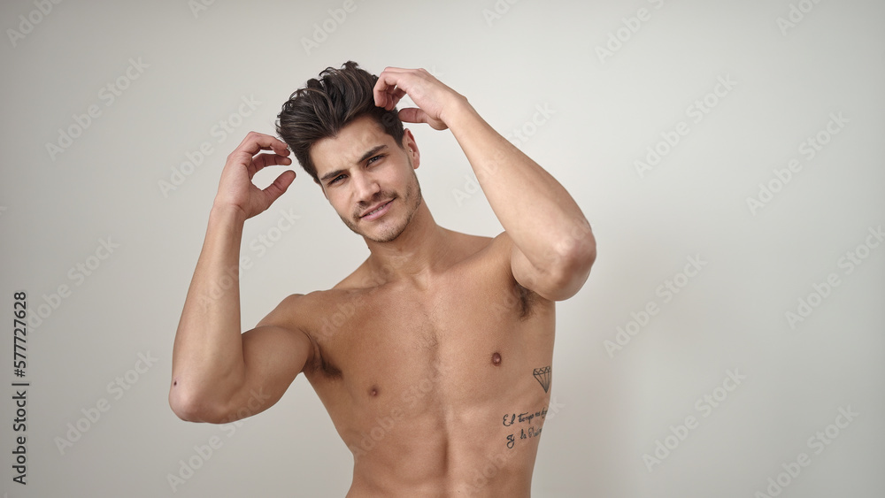 Young hispanic man smiling confident combing hair with hands over isolated white background