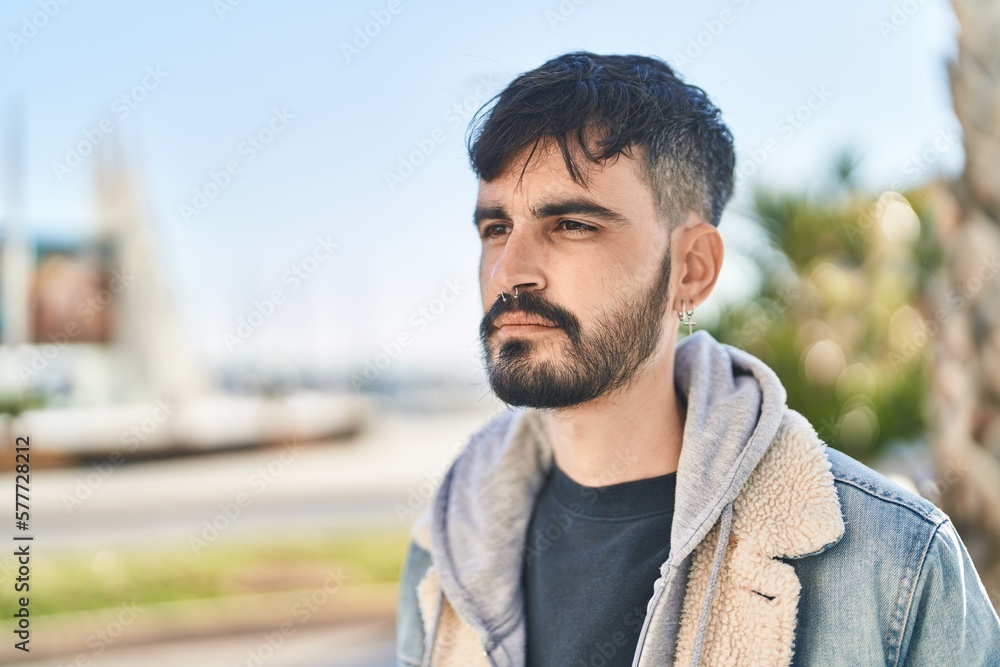 Young hispanic man looking to the side with relaxed expression at street Young hispanic man looking to the side with relaxed expression at street