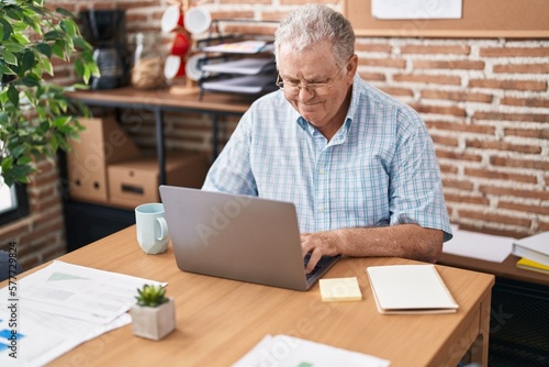 Middle age grey-haired man business worker using laptop working at office