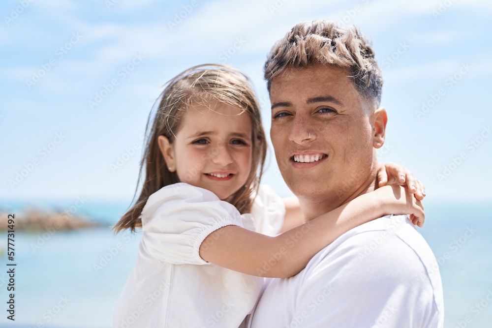 Obraz premium Father and daughter smiling confident hugging each other at seaside