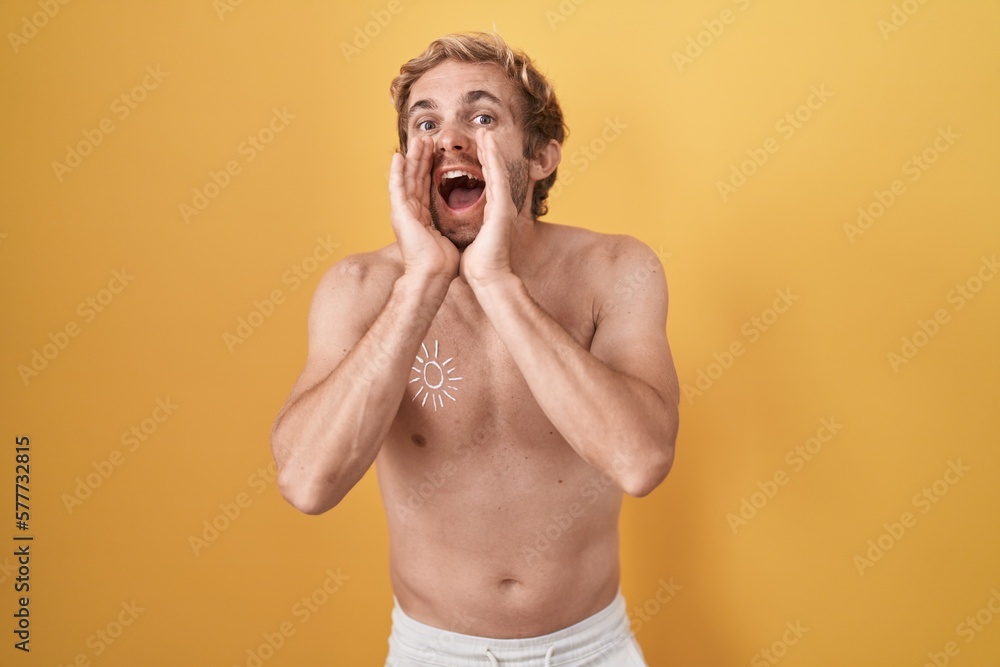 Fototapeta premium Caucasian man standing shirtless wearing sun screen shouting angry out loud with hands over mouth