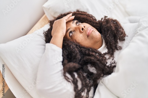 African american woman stressed lying on bed at bedroom