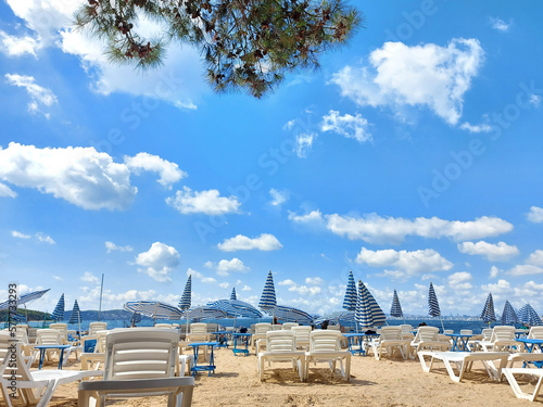 Sun loungers and umbrellas on a sandy beach © Марина Сидоренко