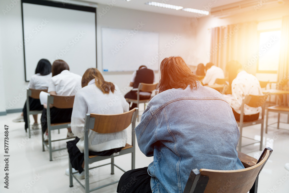 Obraz premium Young teen students taking notes while listening to the lecture in the classroom