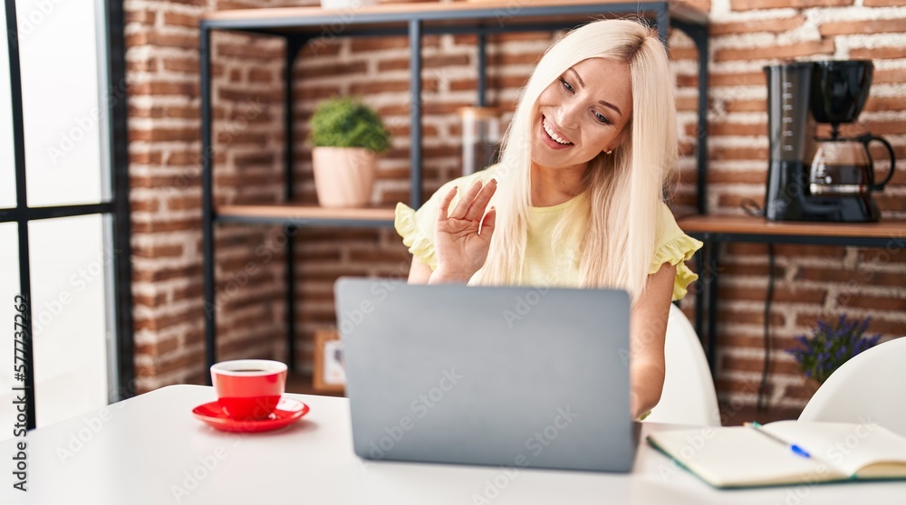 Caucasian woman doing video call with laptop looking positive and happy standing and smiling with a confident smile showing teeth Caucasian woman doing video call with laptop looking positive and happy standing and smiling with a confident smile showing teeth