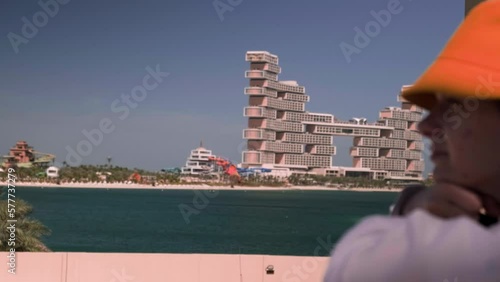 a girl looks into the sea against the backdrop of the Atlantis Royal Dubai hotel, unusual buildings, amazing architecture