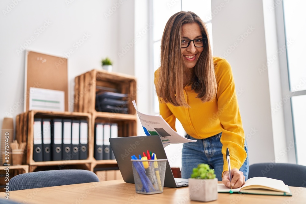 Young woman business worker writing on notebook working at office Young woman business worker writing on notebook working at office
