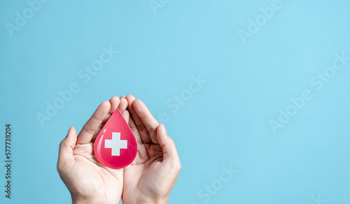 Foto hands holding blood drop paper cut, blood transfusion, world blood donor day, red cross to give blood