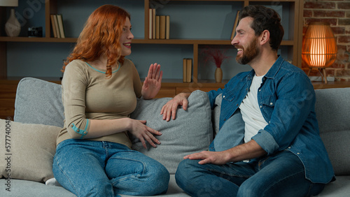 Foto Woman talking with man at home joyful Caucasian couple sit on couch redhead girl