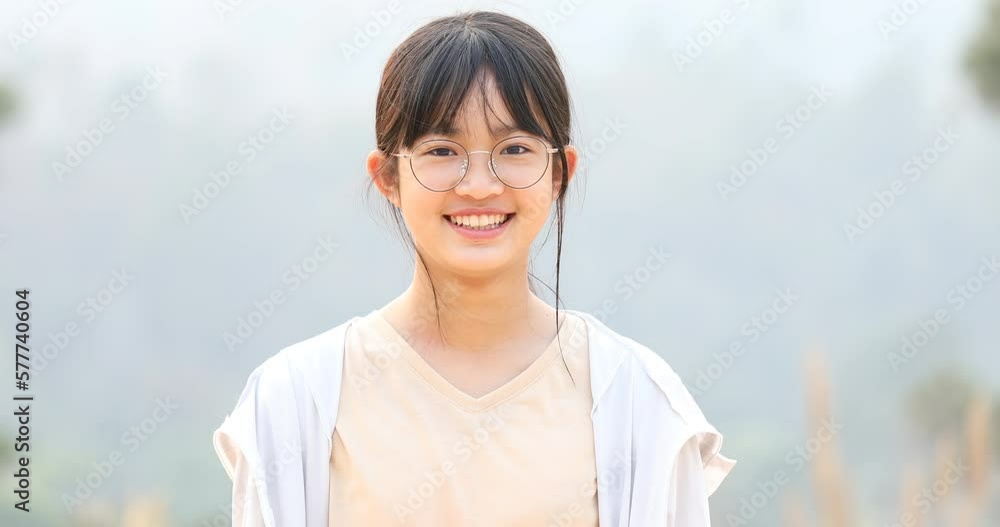 Beautiful Happy asian girl face smiling with glasses and winking looking at camera, . Close up portrait outdoors Beautiful Happy asian girl face smiling with glasses and winking looking at camera, . Close up portrait outdoors