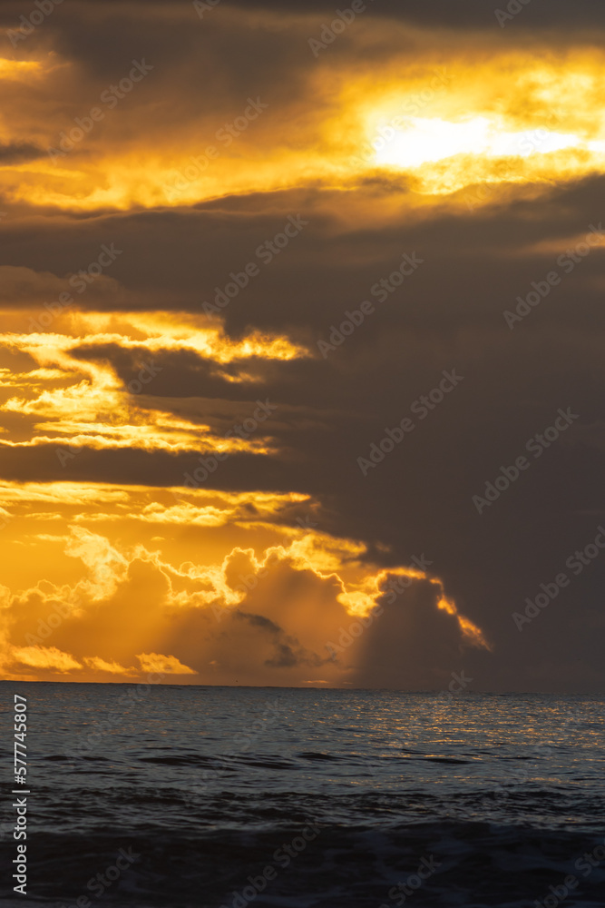 Landscape bright yellow sunset over the dark sea