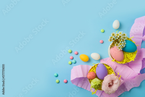 Easter holiday party concept with easter eggs and gift boxes on blue background. Top view, flat lay
