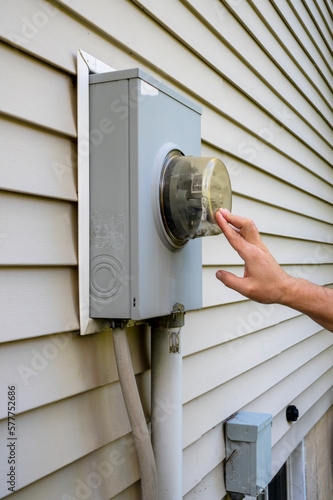 Man looking at electricity meter at home. Electric power box meter for home use, utility bill