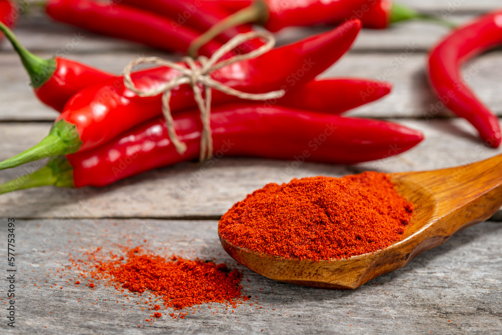 Milled red chili pepper on wooden background Milled red chili pepper on wooden background