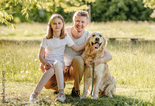 Dad and his daugter play with dog