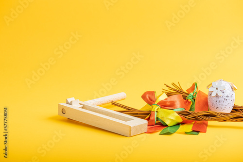Easter whips, egg and rattle clapper on orange background,