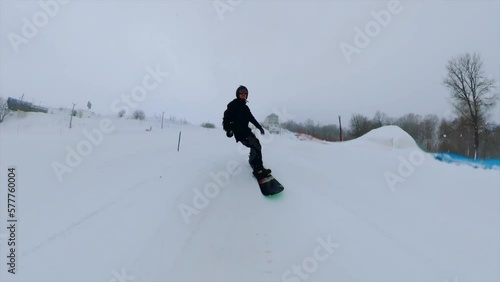 A man in black clothes snowboarding, a snowboarder with a 360 camera, shooting with a 360 camera, snowboarding photo