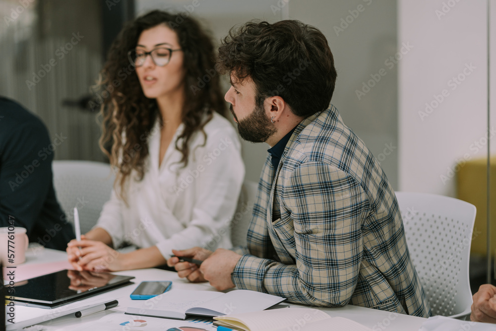 Young male person discussing marketing with his colleagues Young male person discussing marketing with his colleagues