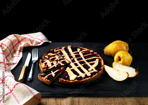 pie and pears are laid out on a black background next to a kitchen towel