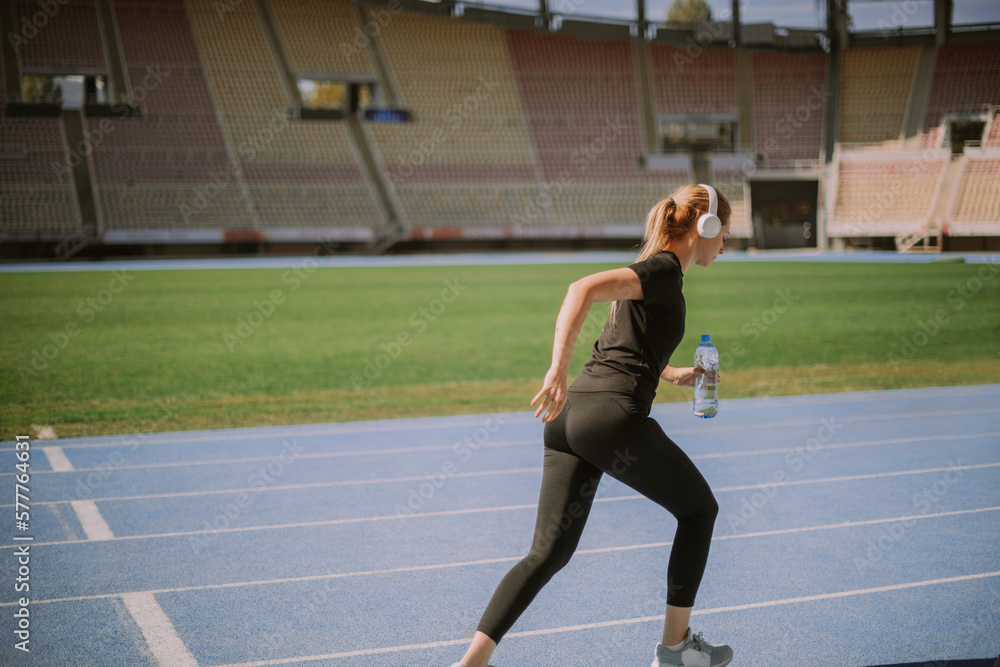 Obraz premium Blonde girl jogging at the stadium