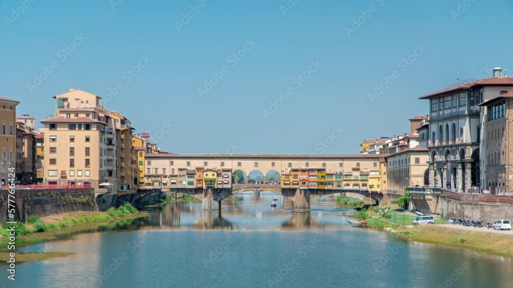 The Ponte Vecchio on a sunny day panoramic timelapse, a medieval stone segmental arch bridge over the Arno River in Florence, Italy, noted for still having shops built along it, as was once common The Ponte Vecchio on a sunny day panoramic timelapse, a medieval stone segmental arch bridge over the Arno River in Florence, Italy, noted for still having shops built along it, as was once common