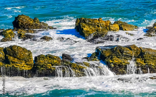 Beautiful rocks cliffs surfer waves at beach Puerto Escondido Mexico.
