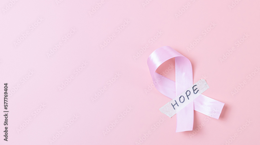 Pink ribbon with sticky tape and the word: hope on a pink background. Pink ribbon with sticky tape and the word: hope on a pink background.