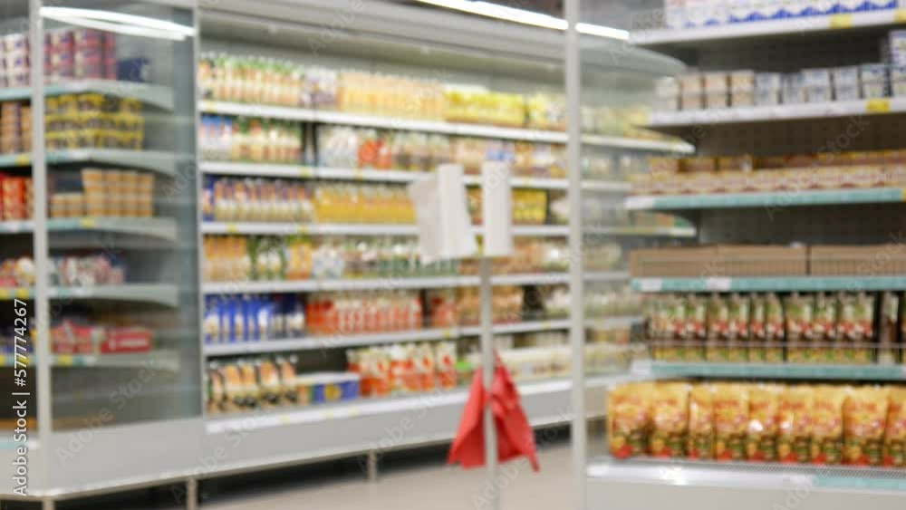 Close-up of a shopping trolley in supermarket and a buyer picks it up and rolls it Close-up of a shopping trolley in supermarket and a buyer picks it up and rolls it