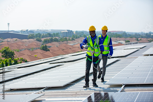 Engineer service check installation solar cell on the roof of factory on the morning.