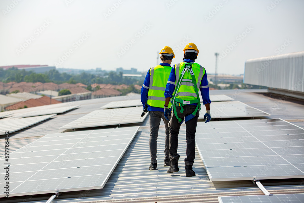 technician in work gloves installing stand-alone photovoltaic solar panel system under beautiful blue sky with clouds. Concept of alternative energy and power sustainable resources. technician in work gloves installing stand-alone photovoltaic solar panel system under beautiful blue sky with clouds. Concept of alternative energy and power sustainable resources.