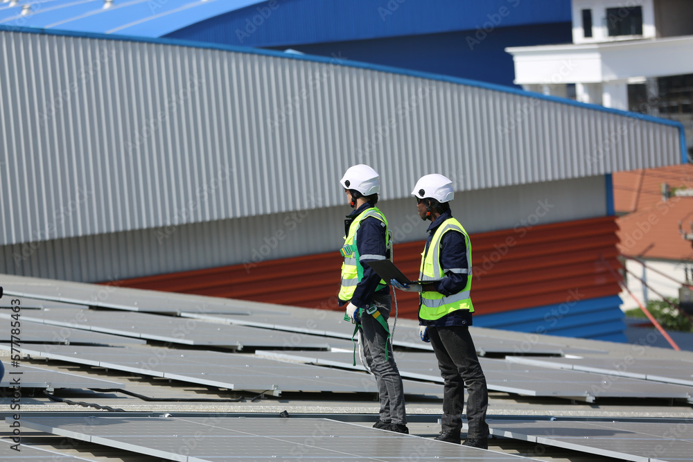 Engineer service check installation solar cell on the roof of factory on the morning. Engineer service check installation solar cell on the roof of factory on the morning.