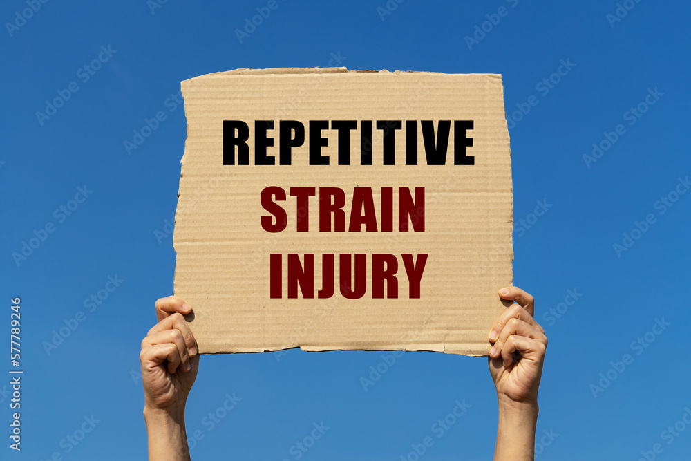 Repetitive strain injury text on box paper held by 2 hands with isolated blue sky background. This message board can be used as business concept to inform audience about ergonomics. and RSI Repetitive strain injury text on box paper held by 2 hands with isolated blue sky background. This message board can be used as business concept to inform audience about ergonomics. and RSI