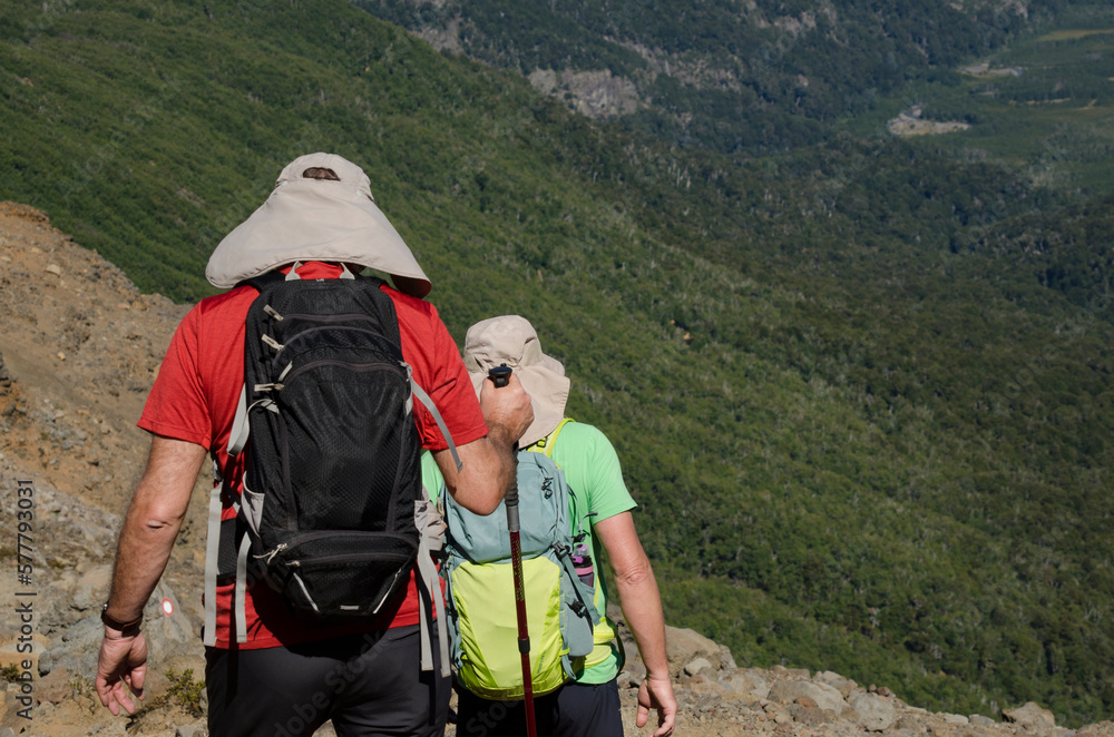dos personas haciendo trekking en la montaña con gorros mochilas y ...