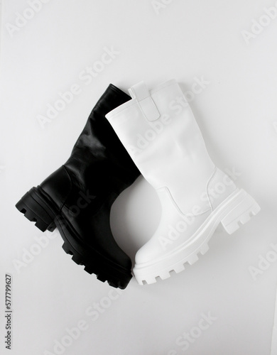 Black and white women's boots on a white background. Flat lay, top view on minimal background. Fashion blog or magazine concept.