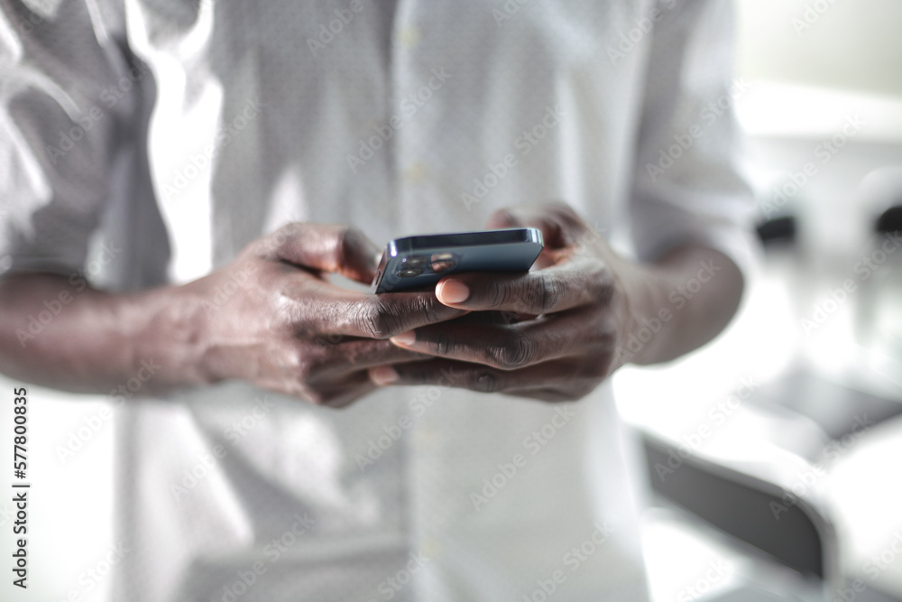 Black businessman enters data into the phone Black businessman enters data into the phone