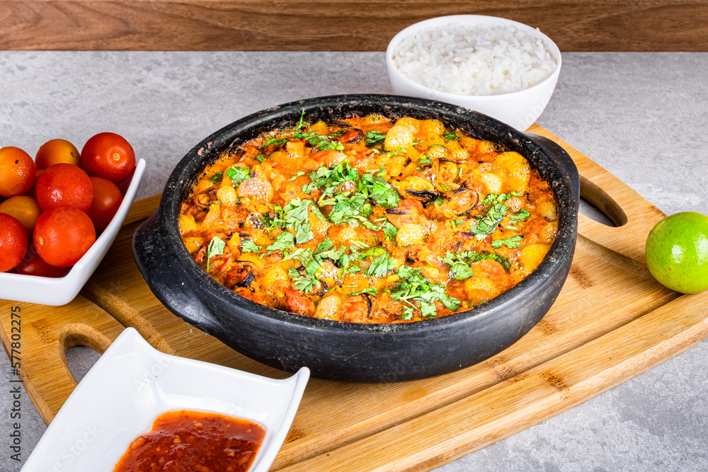 Charru Mussel, known in Brazil as Sururu Moqueca, on wooden board. Beside pepper, lemon, small tomatoes and rice Charru Mussel, known in Brazil as Sururu Moqueca, on wooden board. Beside pepper, lemon, small tomatoes and rice