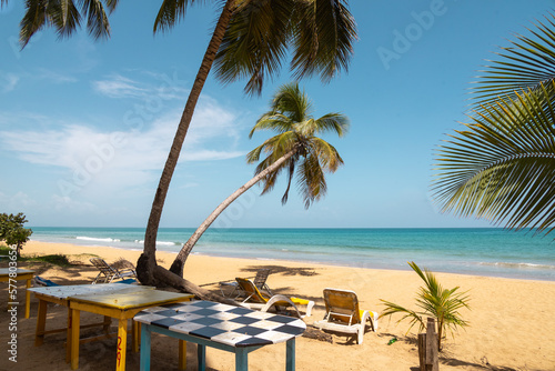 Playa Coson  Dominican Republic  august 2022. View of a typical rustic beach restaurant with plastic chars  palms and amazing sea view.