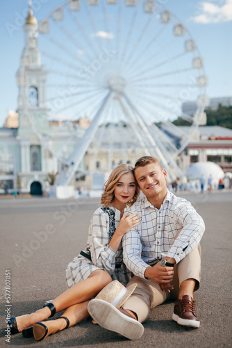 Beautiful couple smiling and posing near ferris wheel