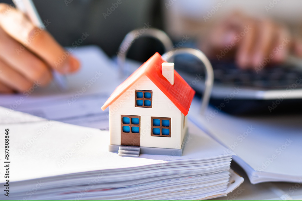 Person Hand Doing Property Tax Calculation Using Calculator Person Hand Doing Property Tax Calculation Using Calculator