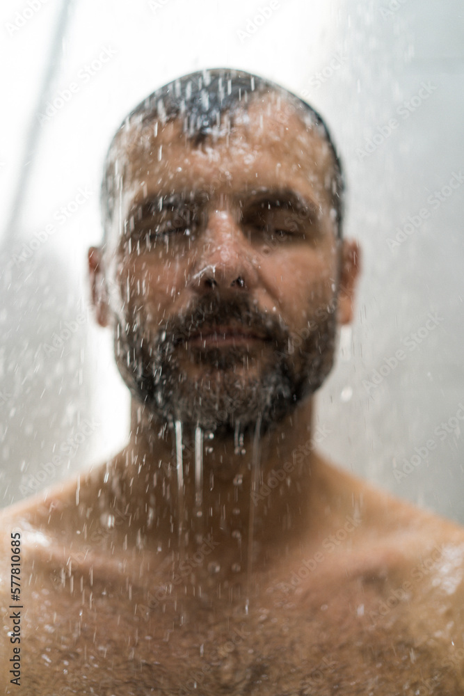 Middle-aged man in the shower, drops of water.