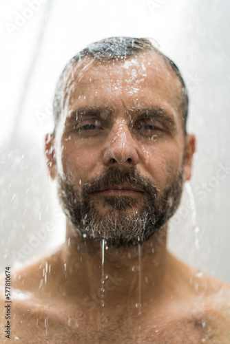 Middle-aged man in the shower, drops of water.