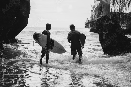Photography Man with a surfboard goes to the Uluwatu surf spot.