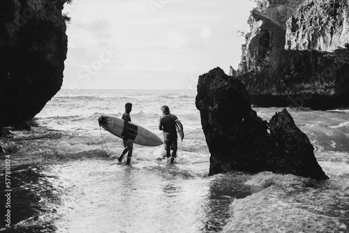 Photography Man with a surfboard goes to the Uluwatu surf spot.